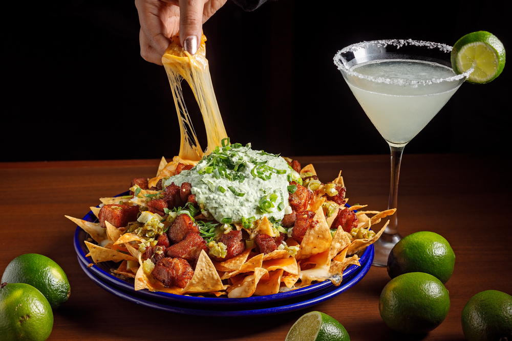Large nachos plate with melted cheese, meat and sour cream served with a Margarita; Shutterstock ID 1709462245; other: ; purchase_order: 123; client: ; job: 